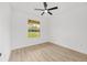 Bright bedroom features wood-look floors, ceiling fan, and window overlooking the yard at 8200 Sw 125Th Court Rd, Dunnellon, FL 34432