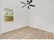 Sunlit bedroom features wood-look floors, a ceiling fan, and a large window at 8200 Sw 125Th Court Rd, Dunnellon, FL 34432
