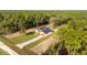 Aerial view of a modern home with green lawn and long concrete driveway at 8200 Sw 125Th Court Rd, Dunnellon, FL 34432