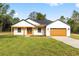 Charming single-story home featuring a manicured lawn, brown garage door, and welcoming covered porch at 8200 Sw 125Th Court Rd, Dunnellon, FL 34432