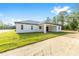 A rear view of a single-story home with a covered patio and green lawn at 8200 Sw 125Th Court Rd, Dunnellon, FL 34432