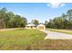Single-story home with a sprawling green lawn, extended driveway, and a charming covered entryway at 8200 Sw 125Th Court Rd, Dunnellon, FL 34432