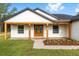 Inviting front porch with wooden columns and a decorative front door, enhanced by newly planted landscaping at 8200 Sw 125Th Court Rd, Dunnellon, FL 34432