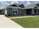 A charming blue house with a well-maintained lawn and landscaping, featuring a two-car garage at 8290 Nw 17Th Cir, Ocala, FL 34475