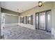 Close up front porch features decorative stone flooring, dark shutters, pendant lighting, and a glass front door at 8465 Sw 101St Ave, Ocala, FL 34481