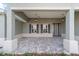 Covered front porch featuring pendant lights, dark shutters, and a decorative stone floor at 8465 Sw 101St Ave, Ocala, FL 34481