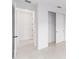 Bright hallway with white walls and trim, featuring doorways to closets and rooms at 8465 Sw 101St Ave, Ocala, FL 34481