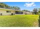 Well-maintained backyard features lush green grass, mature trees and screened-in lanai at 8998 Sw 94Th St # D, Ocala, FL 34481