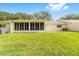 Manicured backyard features beautiful green grass, mature trees, and screened-in lanai at 8998 Sw 94Th St # D, Ocala, FL 34481