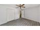 Bedroom boasts updated gray flooring, a ceiling fan and a large closet with folding doors at 8998 Sw 94Th St # D, Ocala, FL 34481