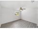 Bright bedroom featuring updated gray flooring, ceiling fan, and a sunny window at 8998 Sw 94Th St # D, Ocala, FL 34481