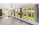 Bright sunroom with ceiling fan and lots of natural light from the many windows overlooking the green backyard at 8998 Sw 94Th St # D, Ocala, FL 34481