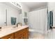 Clean bathroom featuring a vanity with marble-look countertop, a mirror, and a shower with white curtain at 9131 Se 135Th St, Summerfield, FL 34491