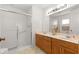 Bathroom featuring a double vanity, a large mirror, and a tiled shower with a glass door at 9131 Se 135Th St, Summerfield, FL 34491