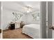 Bright bedroom featuring a ceiling fan, white bedding, and a desk, perfect for a comfortable and productive space at 9131 Se 135Th St, Summerfield, FL 34491