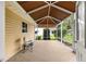 Enclosed patio featuring neutral toned speckled flooring, brown shade screen, and exterior view at 9131 Se 135Th St, Summerfield, FL 34491
