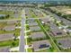 A picturesque aerial view of a neighborhood with green lawns, mature landscaping and a community pond at 9237 Sw 60Th Terrace Rd, Ocala, FL 34476