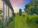 Expansive backyard showing healthy lawn, landscaping and perimeter fence at dusk at 9237 Sw 60Th Terrace Rd, Ocala, FL 34476