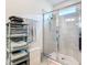 Contemporary bathroom with a glass-enclosed shower, towel rack, and stylish storage shelves for organized essentials at 9237 Sw 60Th Terrace Rd, Ocala, FL 34476