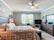 Spacious bedroom featuring ample natural light, a ceiling fan, a dresser and a comfortable bed with cozy decor at 9237 Sw 60Th Terrace Rd, Ocala, FL 34476