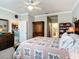 Comfortable bedroom showcasing a ceiling fan, wood furniture, and a doorway view into the kitchen at 9237 Sw 60Th Terrace Rd, Ocala, FL 34476