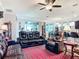 Open living room with brown leather furniture, a ceiling fan, tile flooring and a view to the kitchen and dining area at 9237 Sw 60Th Terrace Rd, Ocala, FL 34476