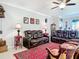 Living room with brown leather furniture, ceiling fan, neutral paint, crown molding and a patterned red area rug at 9237 Sw 60Th Terrace Rd, Ocala, FL 34476