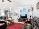 Open living room with tile flooring, neutral paint, crown molding and brown leather furniture, and view to kitchen at 9237 Sw 60Th Terrace Rd, Ocala, FL 34476