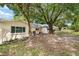 Large backyard space with mature trees, lawn, and a patio featuring a grill and seating area at 9290 Sw 89Th Ter # D, Ocala, FL 34481