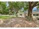 Expansive backyard featuring lush greenery, mature trees, and a patio with grill at 9290 Sw 89Th Ter # D, Ocala, FL 34481