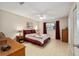 Bright bedroom with a ceiling fan, warm-toned walls, wood furniture and a red and white patterned bedspread at 9290 Sw 89Th Ter # D, Ocala, FL 34481
