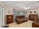 Inviting living room features a plush brown sofa, a large window, and a ceiling fan for comfort at 9290 Sw 89Th Ter # D, Ocala, FL 34481