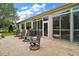 Outdoor patio featuring stylish chairs, a grill, and access to the house, ideal for outdoor enjoyment at 9459 Se 124Th Loop, Summerfield, FL 34491