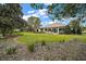 Expansive backyard with well-maintained lawn, a brick-lined garden and a view of the house at 9459 Se 124Th Loop, Summerfield, FL 34491