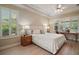Comfortable bedroom with wood floors, plantation shutters, and an adjacent workstation at 9459 Se 124Th Loop, Summerfield, FL 34491