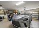 Organized garage with a modern silver SUV, storage shelving, and an automatic door opener, great for convenience at 9459 Se 124Th Loop, Summerfield, FL 34491