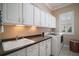 Well-lit laundry room with white cabinets, a sink, and a washing machine, offering convenience and functionality at 9459 Se 124Th Loop, Summerfield, FL 34491