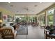 Bright living room with many windows, seating, ceiling fan, and natural light, offering a relaxing atmosphere at 9459 Se 124Th Loop, Summerfield, FL 34491