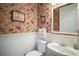 Charming powder room featuring floral wallpaper, wainscoting, and a decorative mirror at 9459 Se 124Th Loop, Summerfield, FL 34491