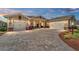 Charming single-story home at dusk, featuring a brick paved driveway and two-car garage in a well manicured yard at 9607 Sw 79Th Lane Rd, Ocala, FL 34481