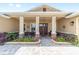 Inviting front porch with stone pillars and beautiful landscaping offering a relaxing outdoor seating area at 9607 Sw 79Th Lane Rd, Ocala, FL 34481