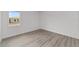 Bright bedroom featuring wood-look flooring, white trim, and a window for ample natural light at 9813 Sw 105Th Ct, Ocala, FL 34481