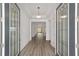 Bright foyer featuring wood floors, tray ceiling, and glass paneled doors at 9813 Sw 105Th Ct, Ocala, FL 34481