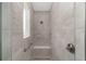 Bright stand up shower with showerhead, seat, safety bar, and tiled walls at 9813 Sw 105Th Ct, Ocala, FL 34481
