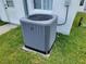 A close up of an energy-efficient air conditioner unit sitting on a green lawn in front of a white building at 10269 Sw 63Rd Ave, Ocala, FL 34476