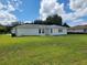 Back exterior view of the home with a door and windows at 10269 Sw 63Rd Ave, Ocala, FL 34476