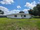 Back exterior view of the home with a lush green lawn at 10269 Sw 63Rd Ave, Ocala, FL 34476