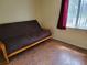 Bedroom showcasing a futon, wood laminate floors, natural light from the window at 10269 Sw 63Rd Ave, Ocala, FL 34476