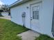 Exterior view of a white house with a door, an electrical box, and a small window with a white frame at 10269 Sw 63Rd Ave, Ocala, FL 34476