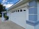 White garage door with decorative windows in a well-maintained home with painted concrete accents at 10269 Sw 63Rd Ave, Ocala, FL 34476